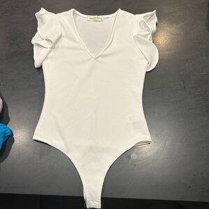 Cream flutter sleeved body suit.  Size small.